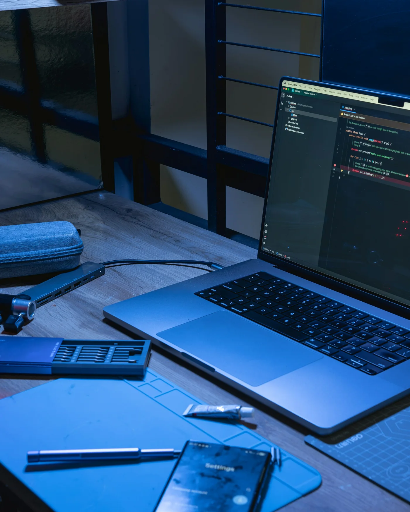 Laptop mit geöffnetem Code-Editor an einem Arbeitsplatz